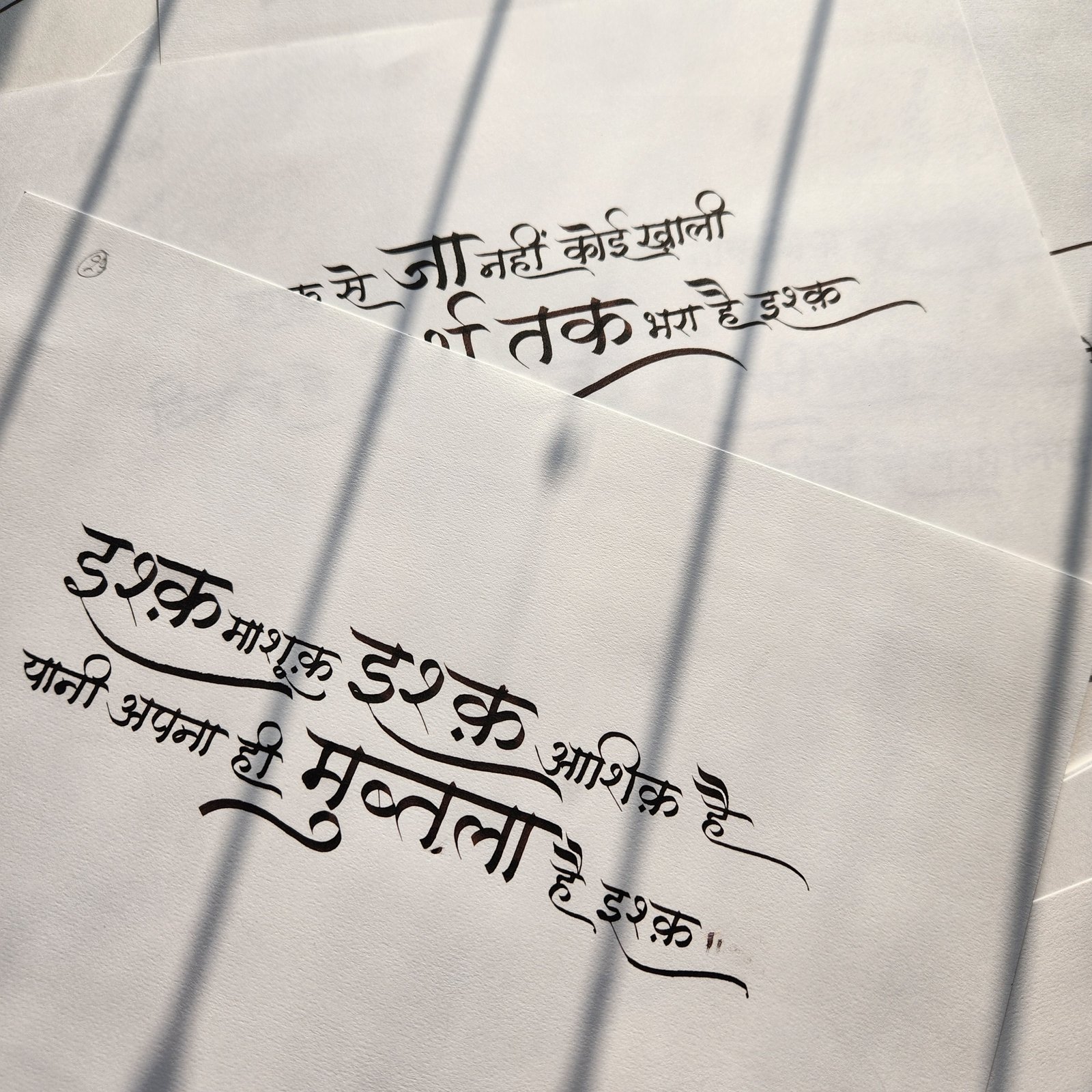 Devanagari couplet in black ink, with long flourished connecting strokes