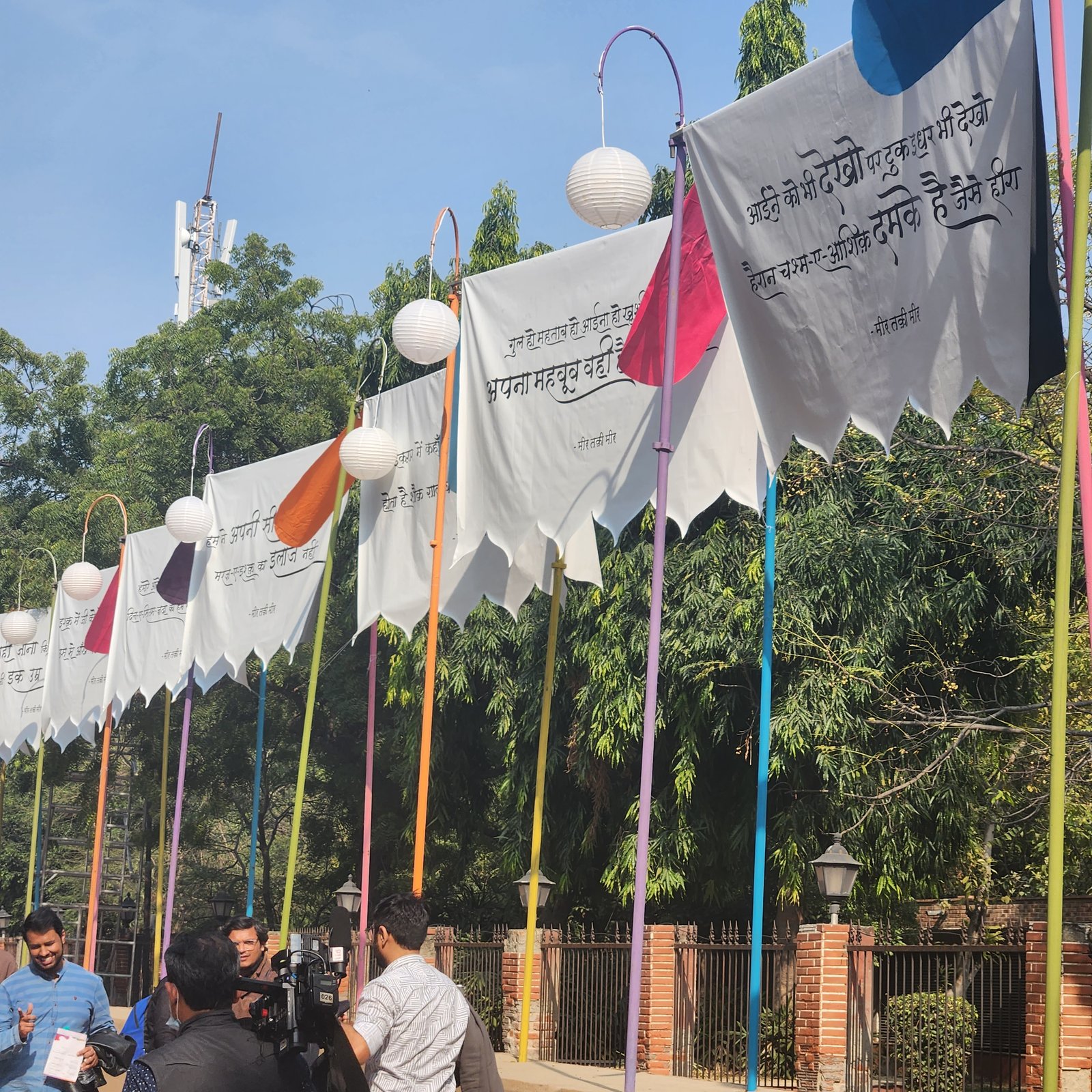 Devanagari couplets by Mir Taqi Mir lettered onto festival banners at an outdoor installation