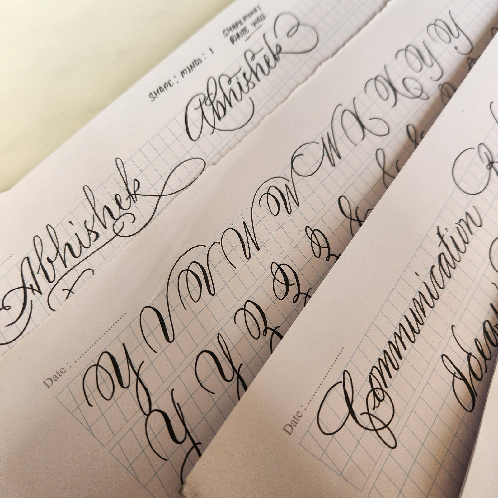 Flourished names and ornamental capitals across practice sheets